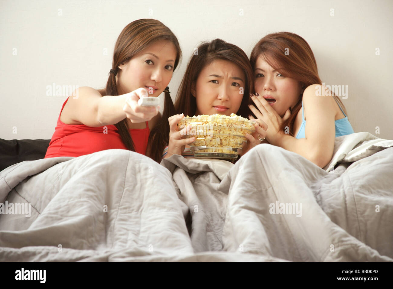 Giovani donne sdraiato sul letto a guardare la TV Foto Stock