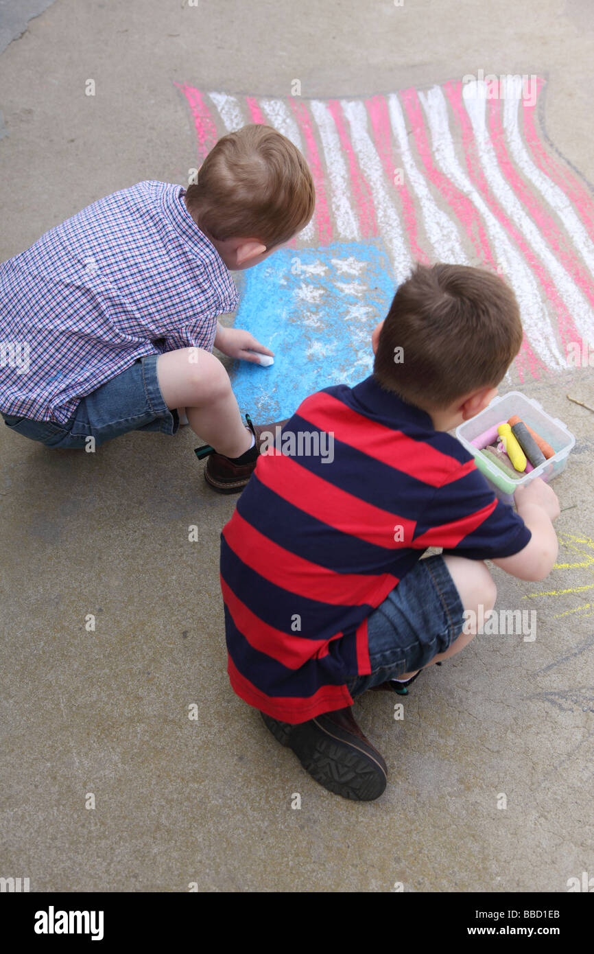 Due giovani ragazzi disegnare bandiera americana sul marciapiede Foto Stock