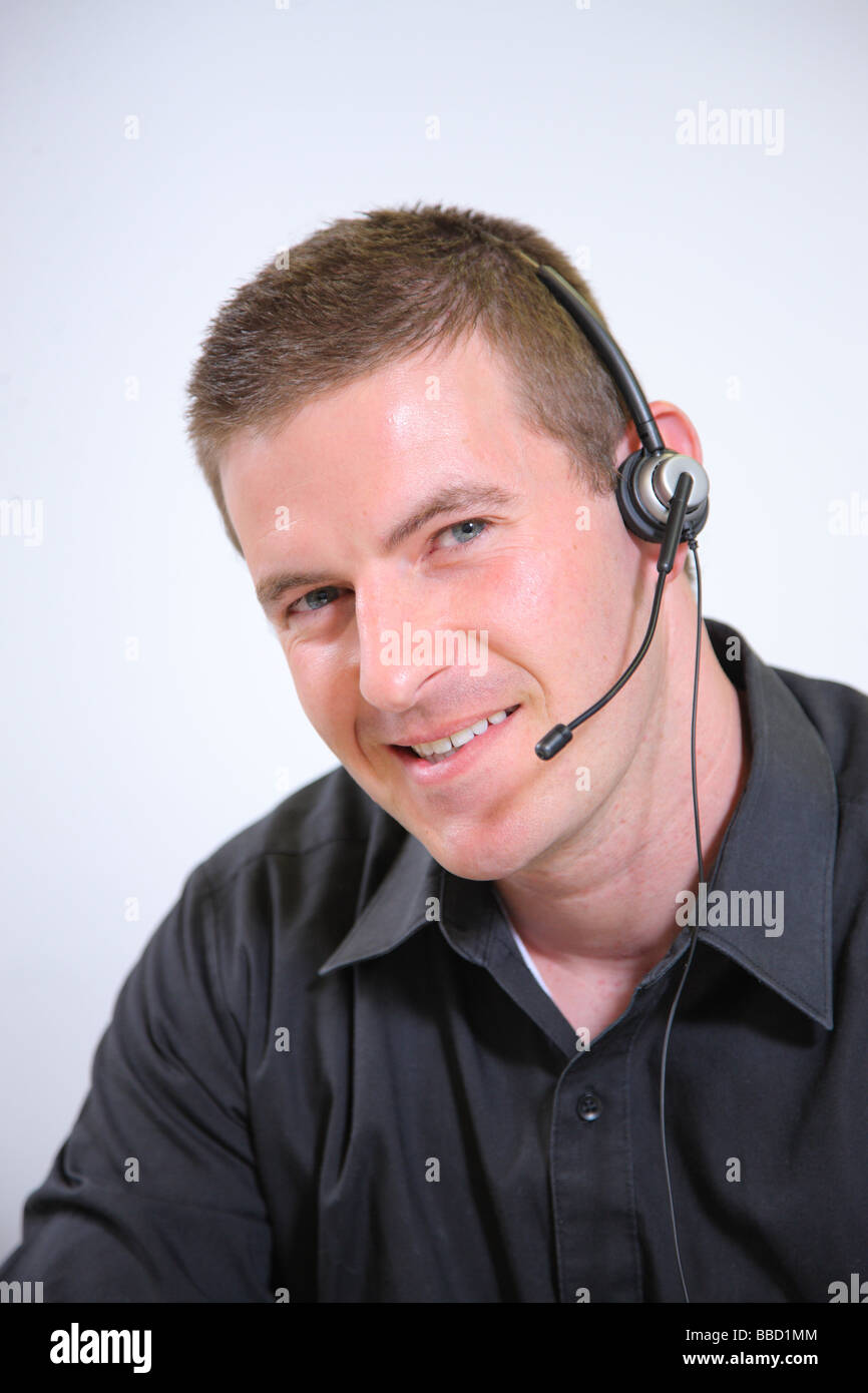 Giovane Uomo con cuffie sorridente in telecamera Foto Stock