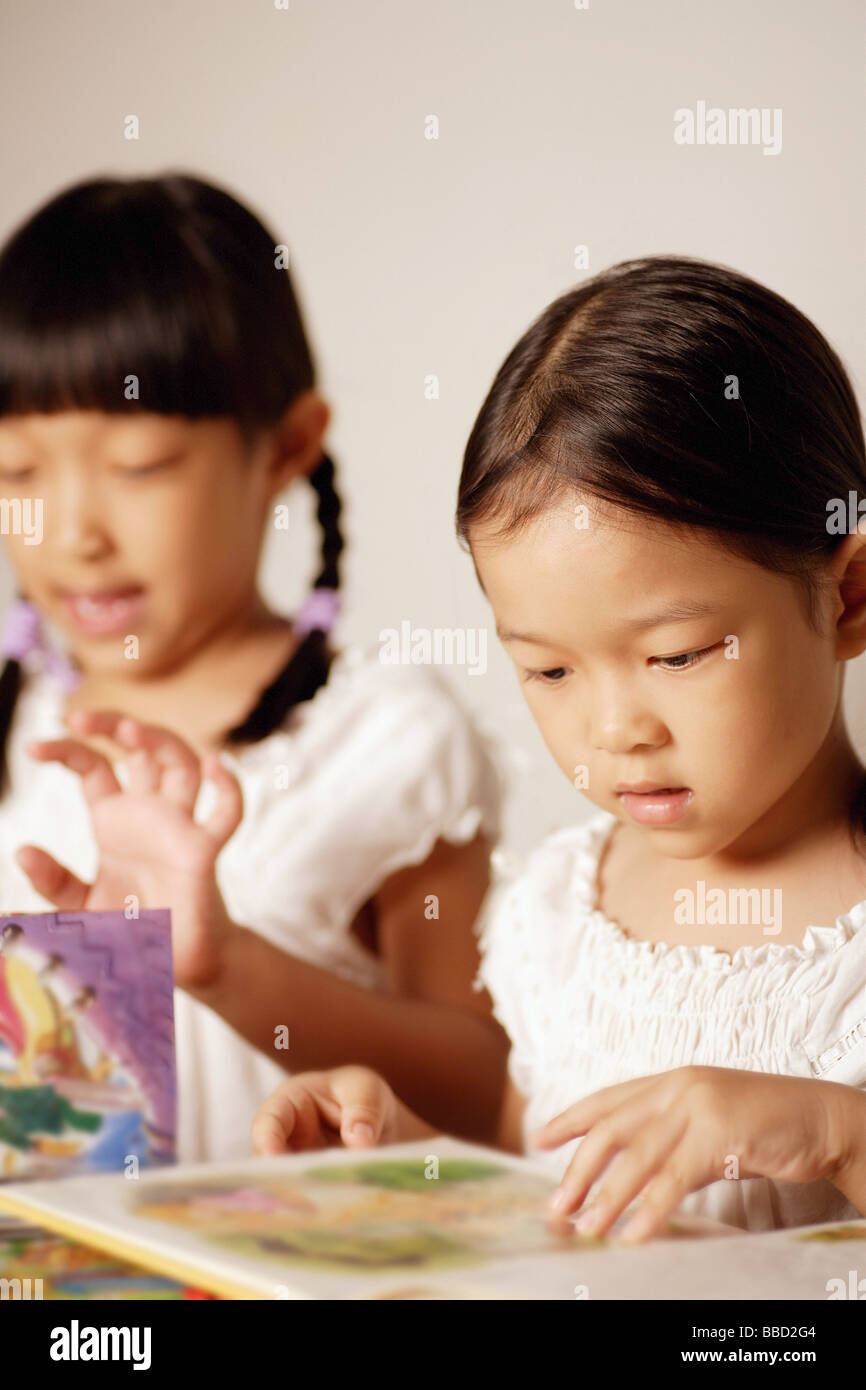 Due ragazze guardando libri fianco a fianco Foto Stock