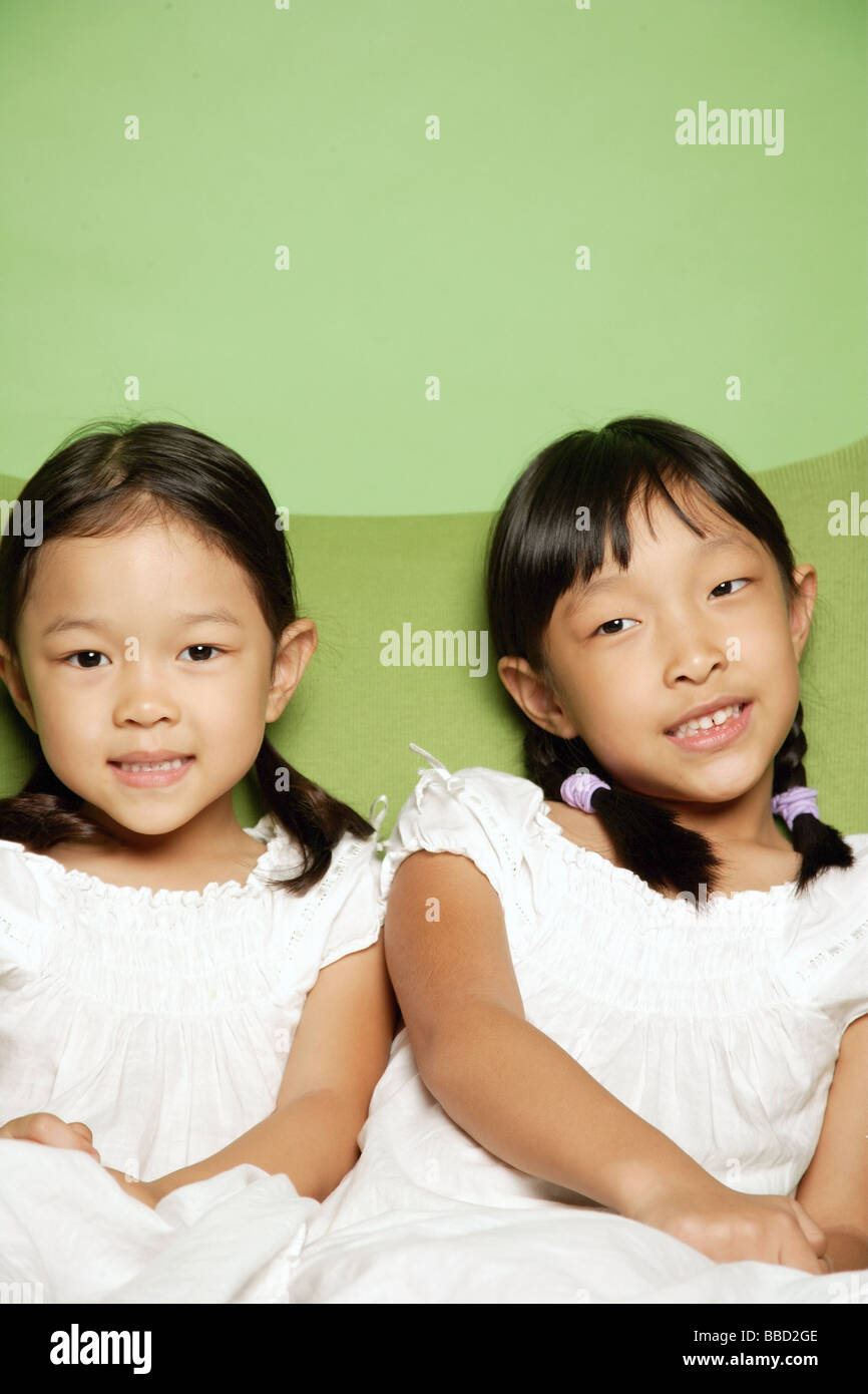 Due sorelle seduti fianco a fianco Foto Stock