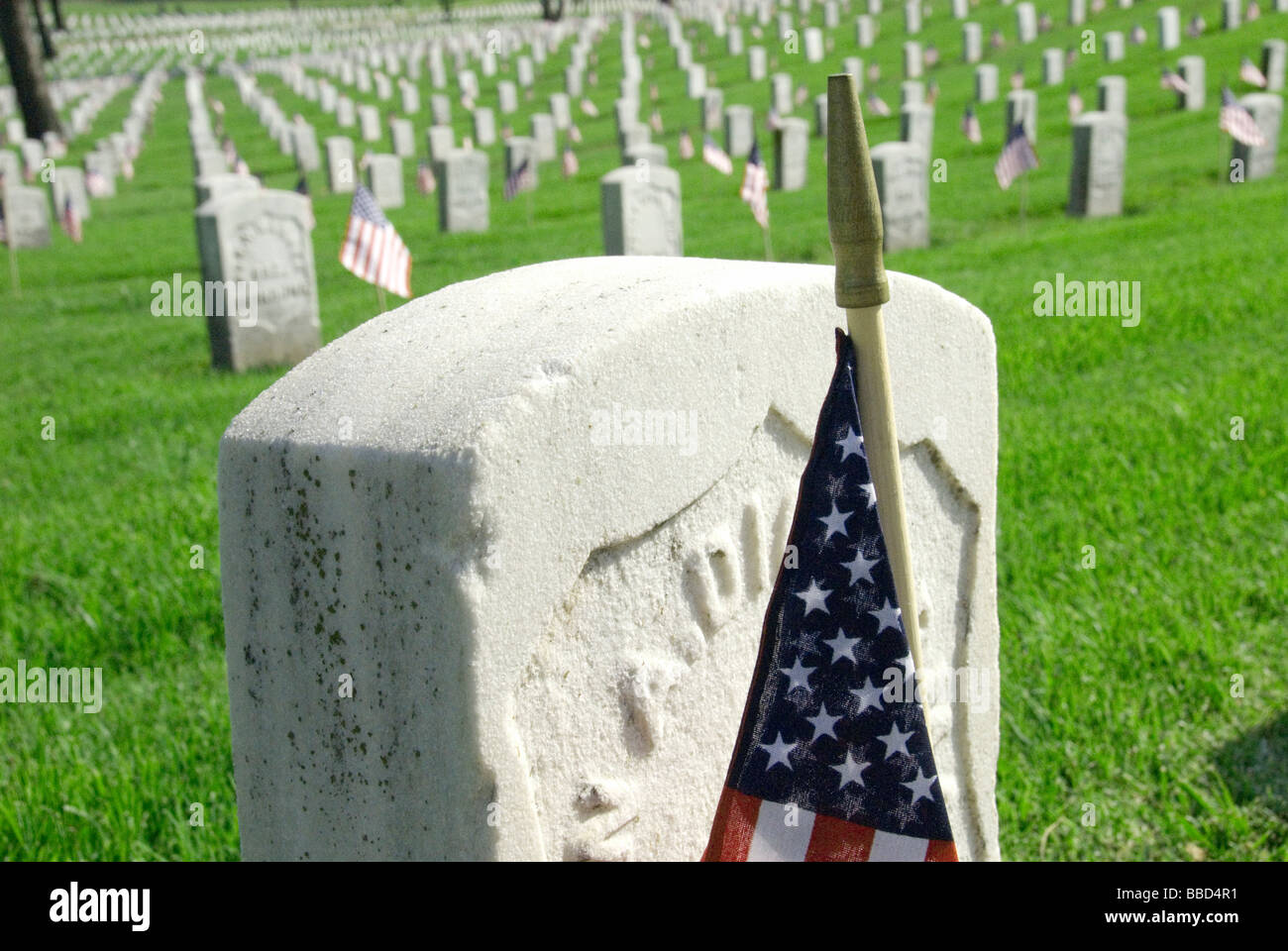 Close-up di una bandiera americana che segna la pietra tombale di un eroe di guerra. Foto Stock