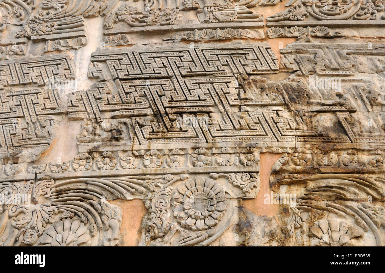 Decorazioni scolpite su un muro di pietra a Sarnath, il parco dei cervi dove Siddharta Gautama che beame il Buddha ha insegnato prima. Foto Stock