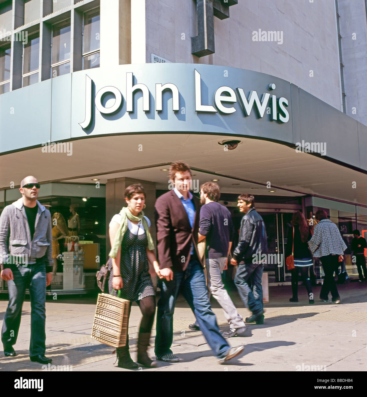 Gli amanti dello shopping con sacchetti di passato a piedi l'ingresso al John Lewis department store in Oxford Street Londra Inghilterra REGNO UNITO Foto Stock