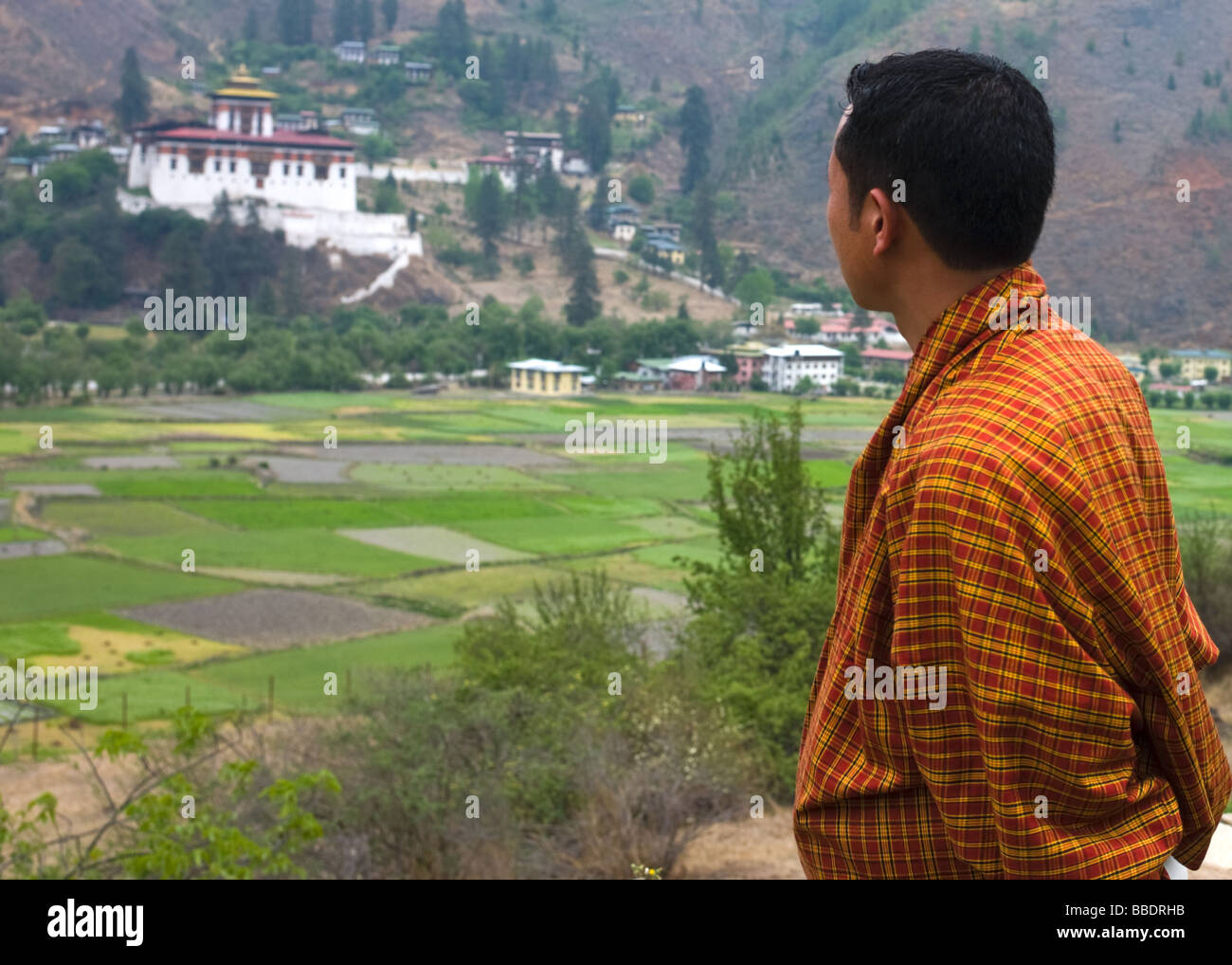 Un uomo bhutanesi guardando a paro Dzong - Paro, Bhutan Foto Stock