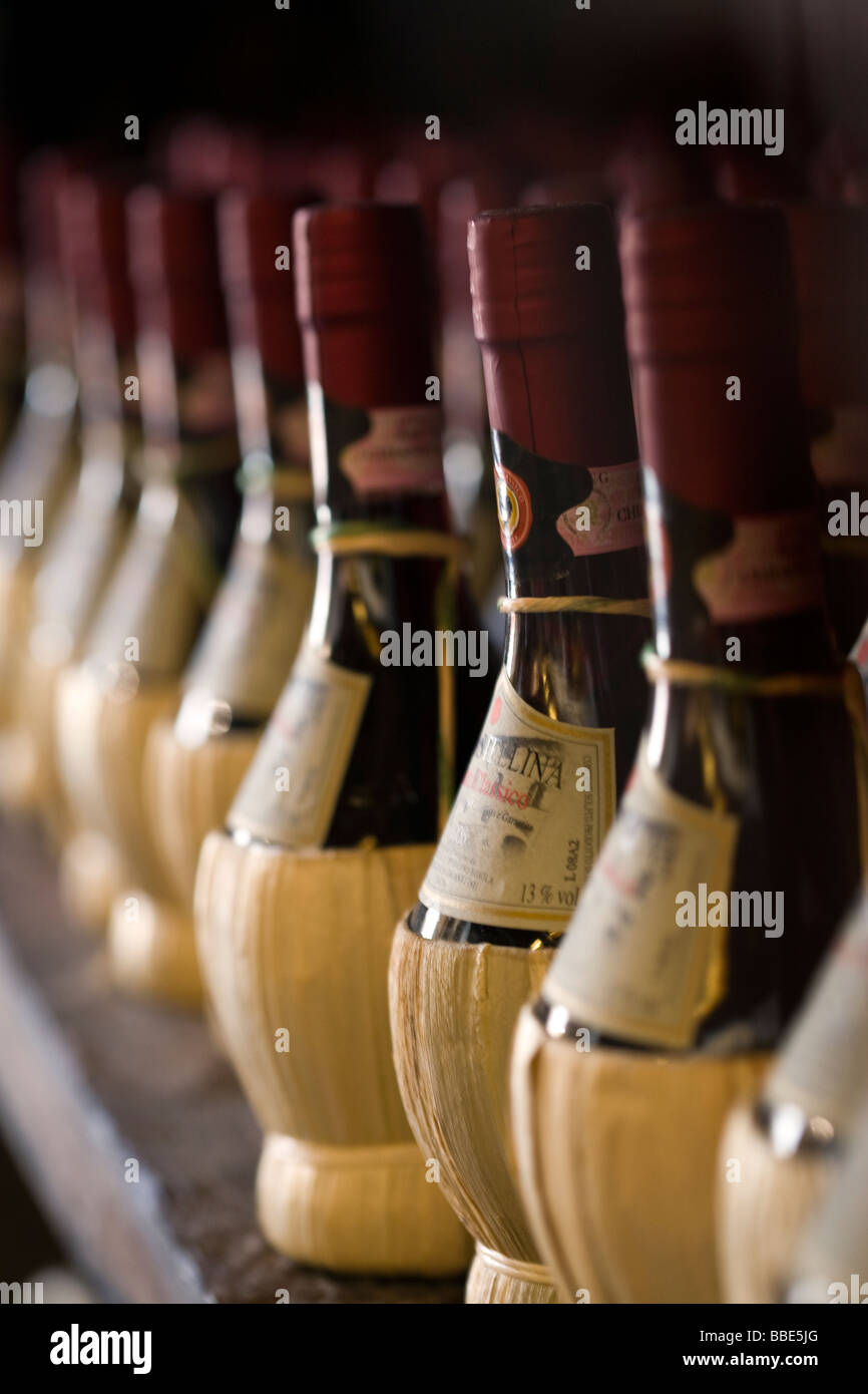 Il Chianti Classico bottiglie di vino rosso avvolto in paglia su una cremagliera Foto Stock