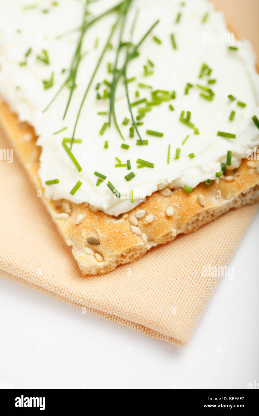 Fette biscottate con crema di formaggio e erba cipollina sul panno assorbente Foto Stock