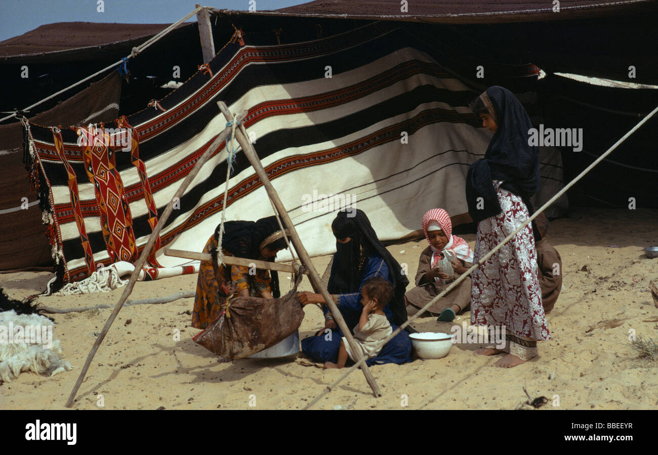 Il Qatar Medio Oriente Golfo membro persone beduino donne e bambini seduti sulla sabbia fuori tenda nomade Foto Stock