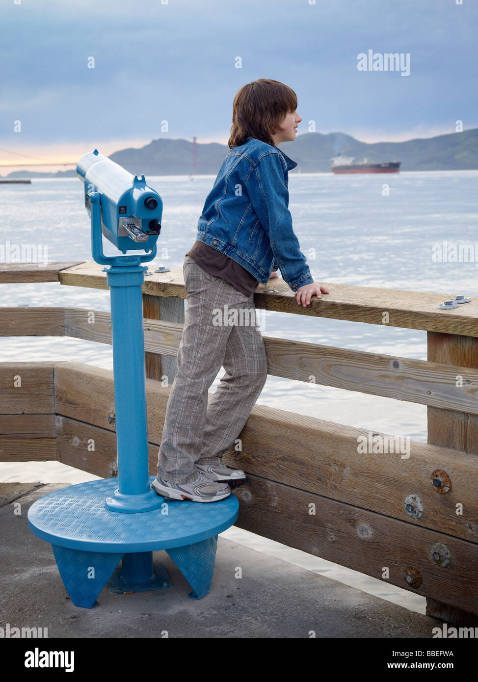 Ragazzo che guarda oltre l'acqua dal Molo di San Francisco, California, Stati Uniti d'America Foto Stock