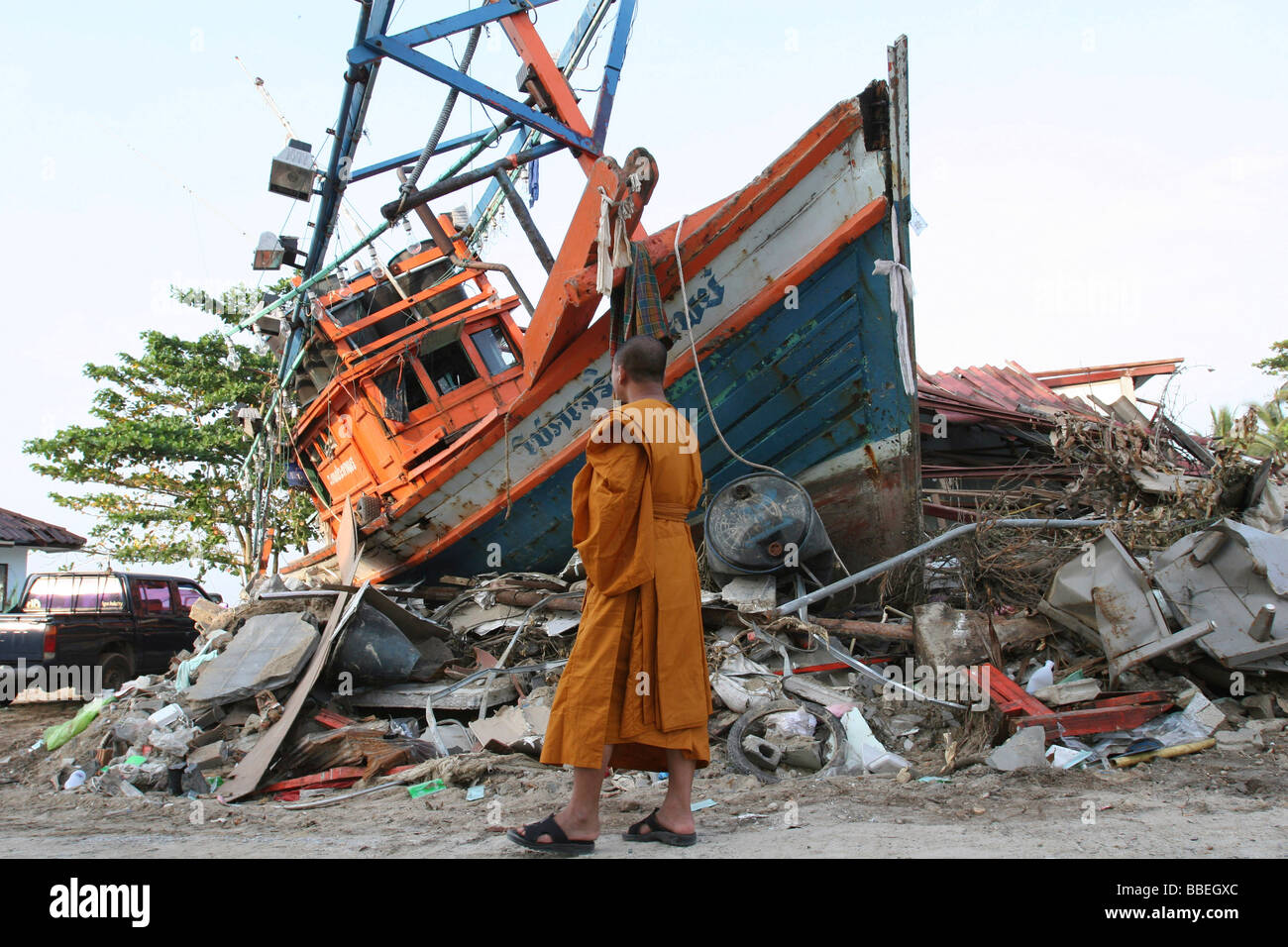 Thailandia Phang Nga Nam Khem Tsunami. Monaco buddista guarda i danni causati dal disastro dello tsunami in piedi in barca fregata su strada Foto Stock