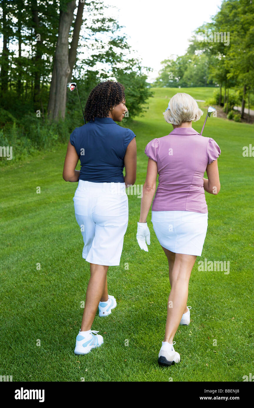 Vista posteriore delle donne camminando sul campo da Golf Foto Stock