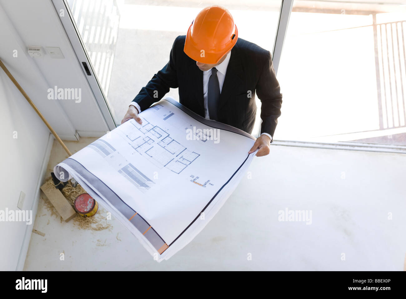 Uomo in tuta indossare elmetto guardando il blueprint Foto Stock