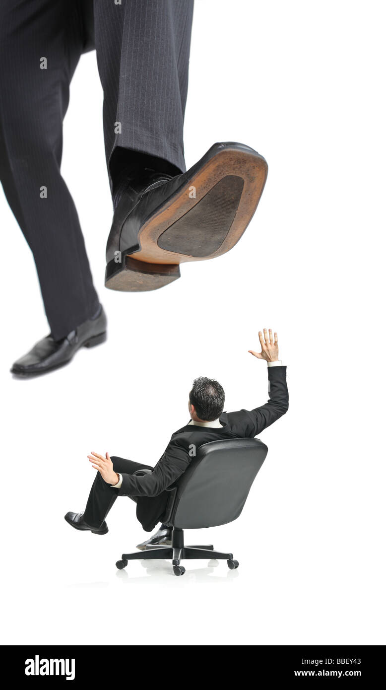 Un gigante di piede attorno a squish un imprenditore in una sedia Foto Stock
