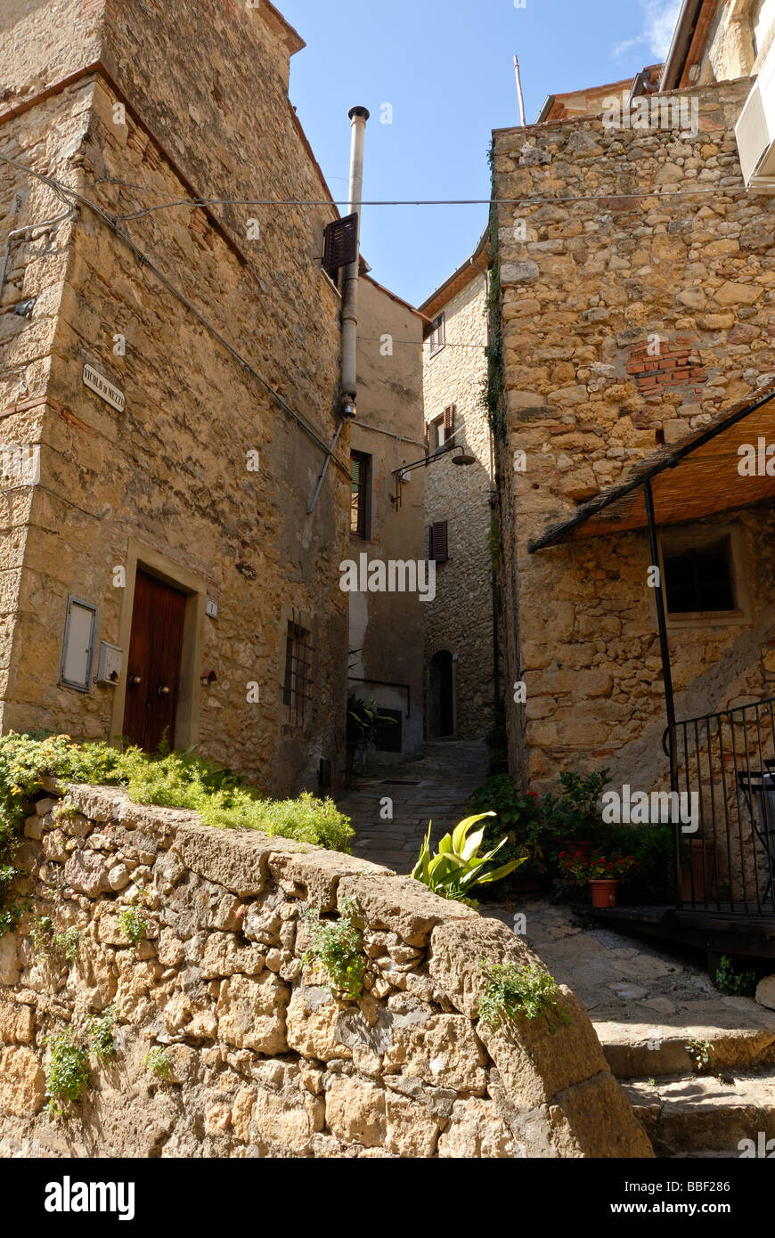 Toscana (Toscana) Italia - basso angolo di visione dell'esterno dell'edificio con pareti di pietra nella città medievale di Casale Marittimo Foto Stock