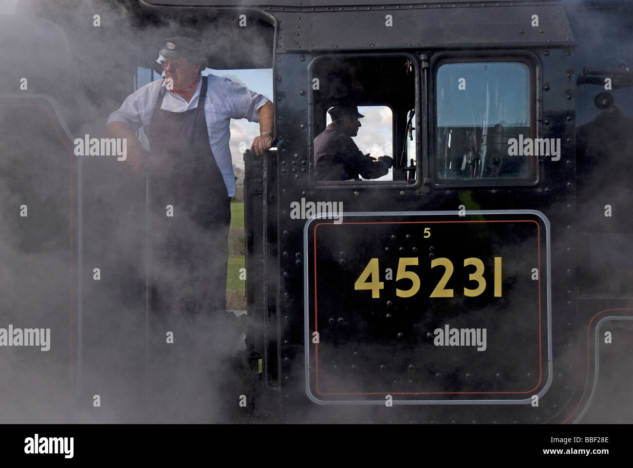 Treno a vapore driver sul West Somerset Railway. Foto Stock