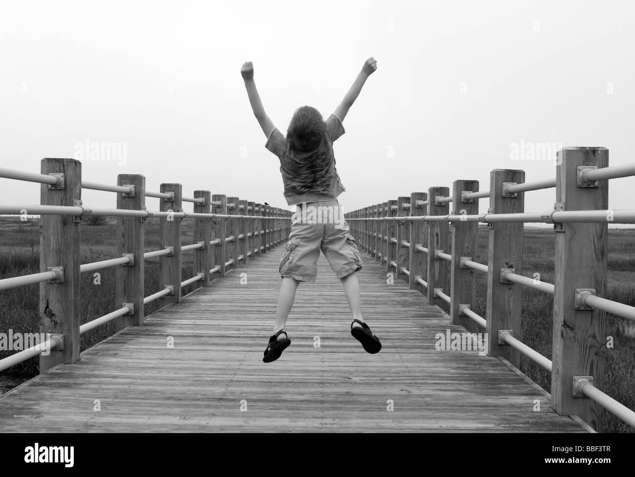 I bambini con salti di gioia lungo una passerella in Milford Connecticut USA Foto Stock