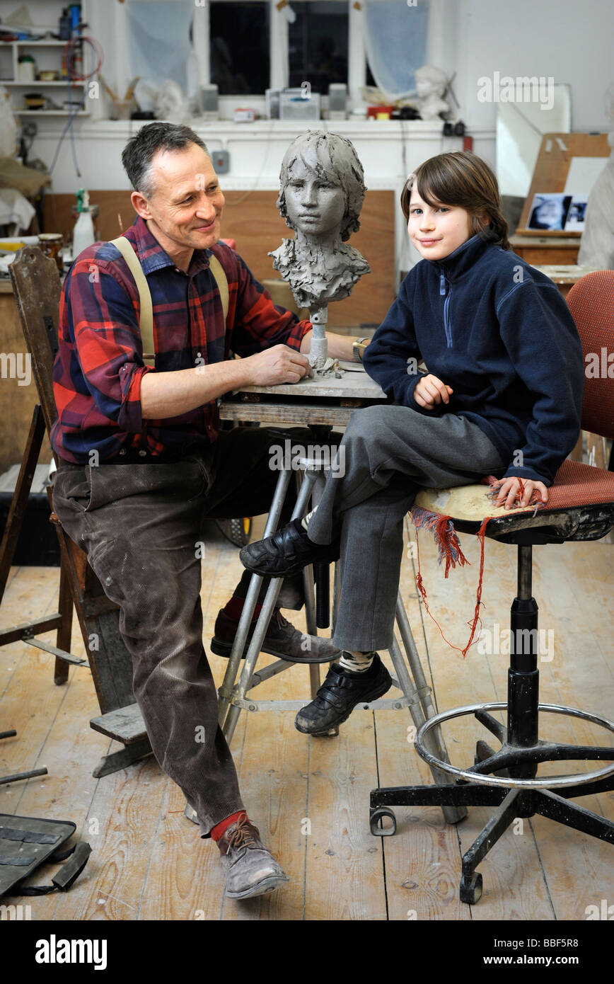 Scultore Mark Richards nel suo studio vicino a Ludlow lavorando su una testa di argilla di suo figlio Gil 2008 Foto Stock