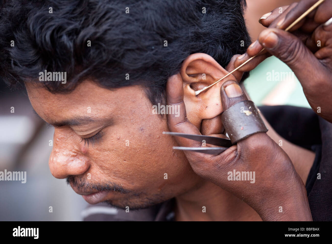 Pulizia auricolare nella Vecchia Delhi India Foto Stock