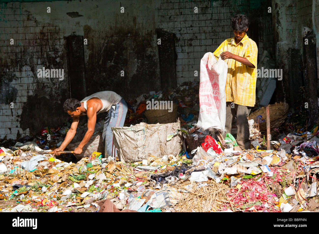 Indian uomini rovistare attraverso un mucchio di rifiuti per trovare scarti di riciclare nella Vecchia Delhi India Foto Stock