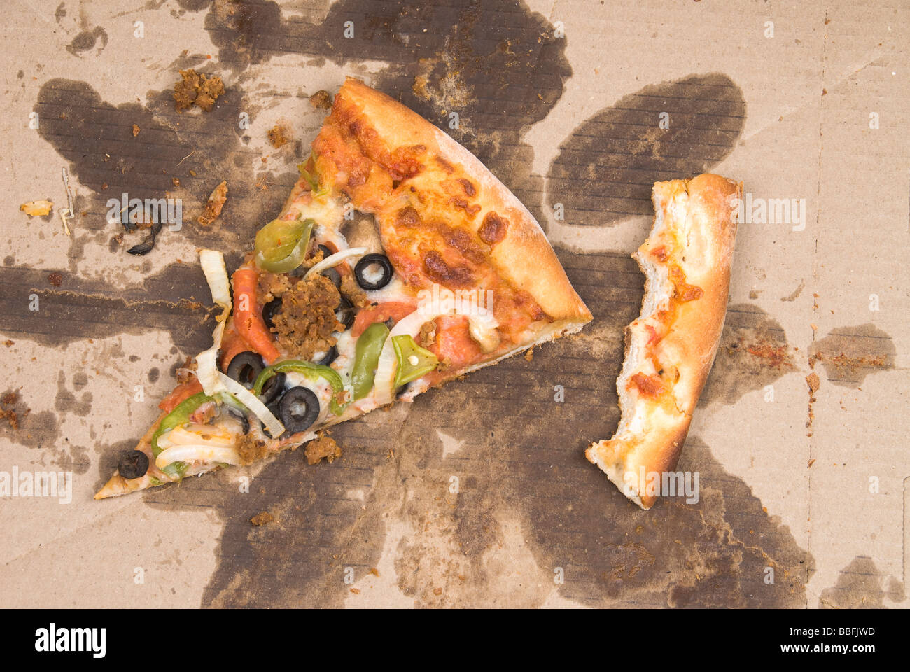 Una fetta di sinistra sopra la pizza e una crosta mangiato tallone in una scatola pizza Foto Stock