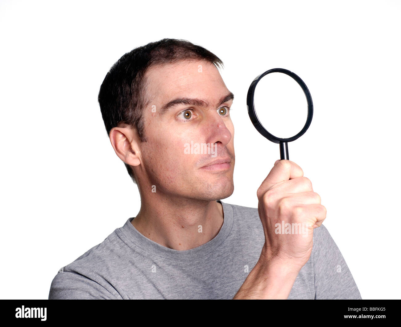 Uomo che guarda attraverso la lente di ingrandimento Foto Stock