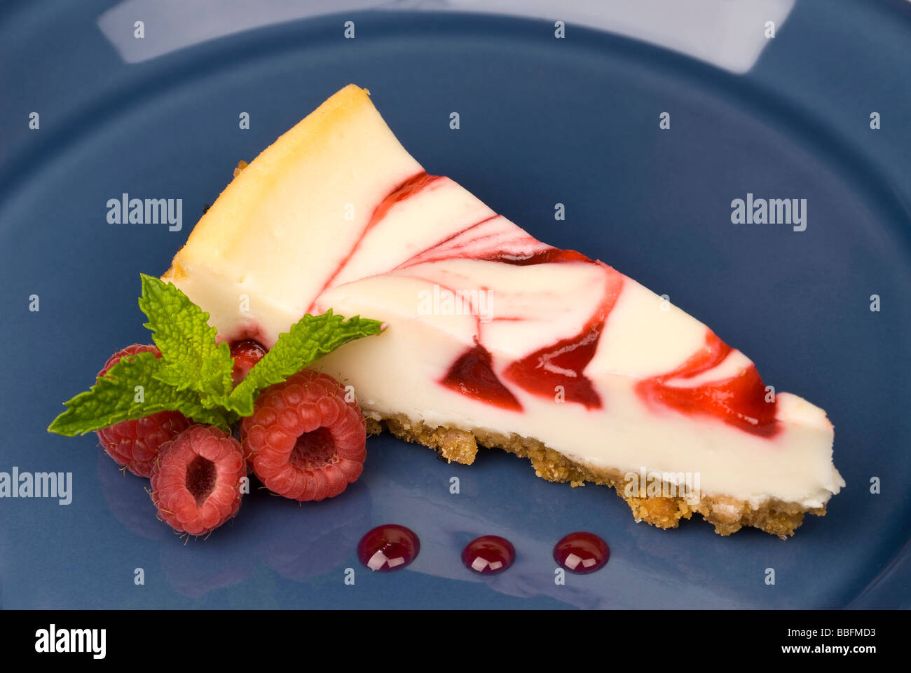 Una fetta di lampone cheesecake dessert con foglie di menta su un piatto di portata Foto Stock