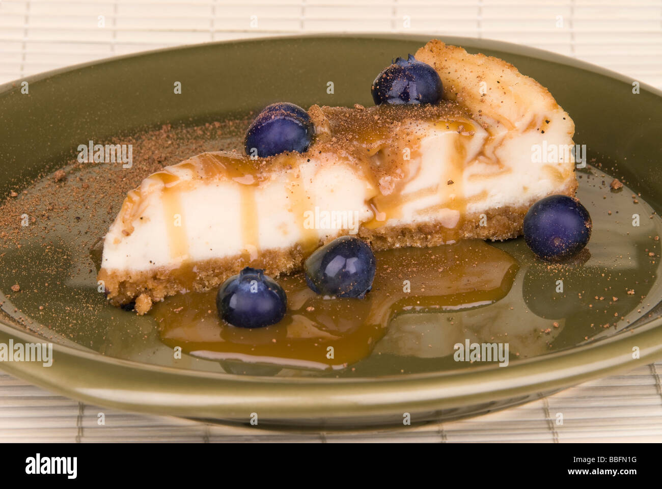 Una fetta di caramello cheesecake rivestito con blurberries e un pizzico di noce moscata Foto Stock