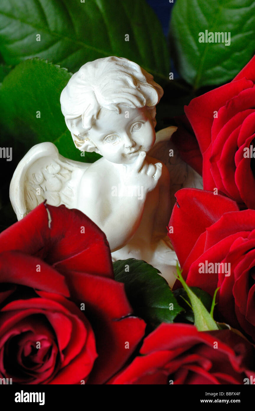Angelo in ceramica figurine con rose rosse Foto Stock