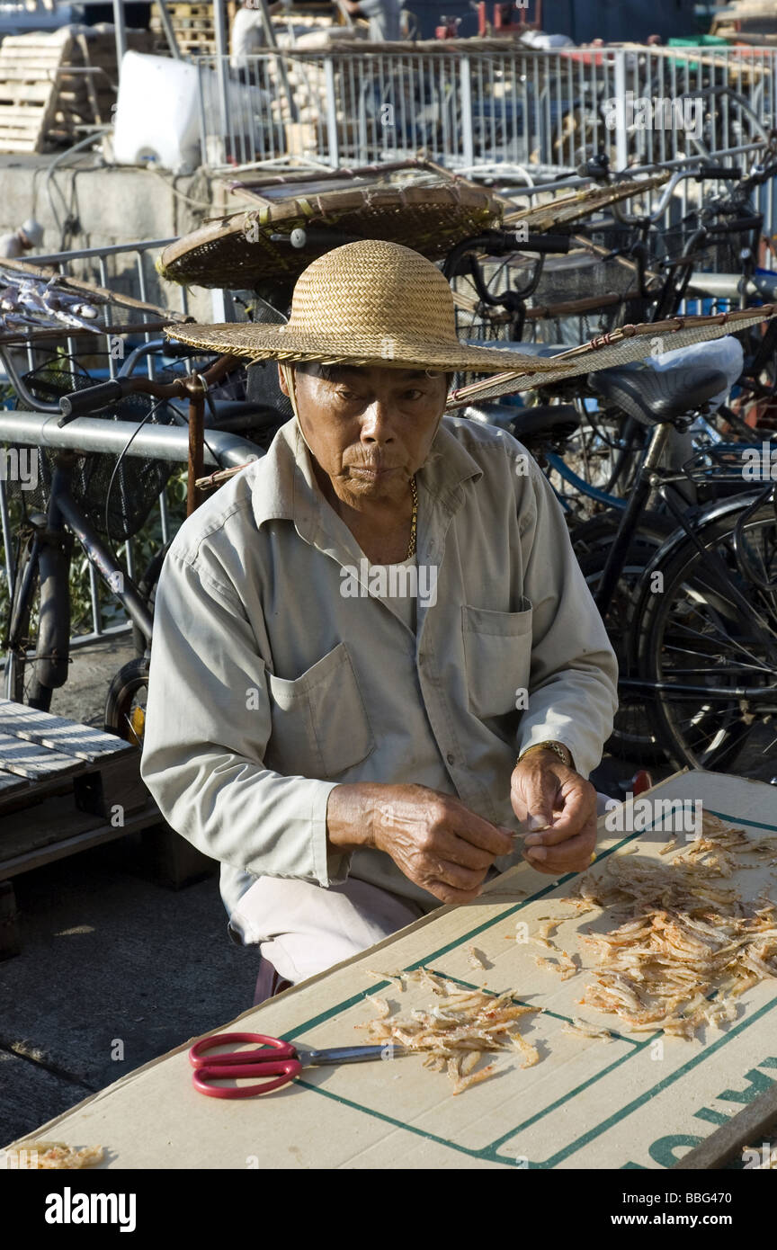Hong Kong, Cheung Chau Isola, uomo locale di preparazione del pesce Foto Stock