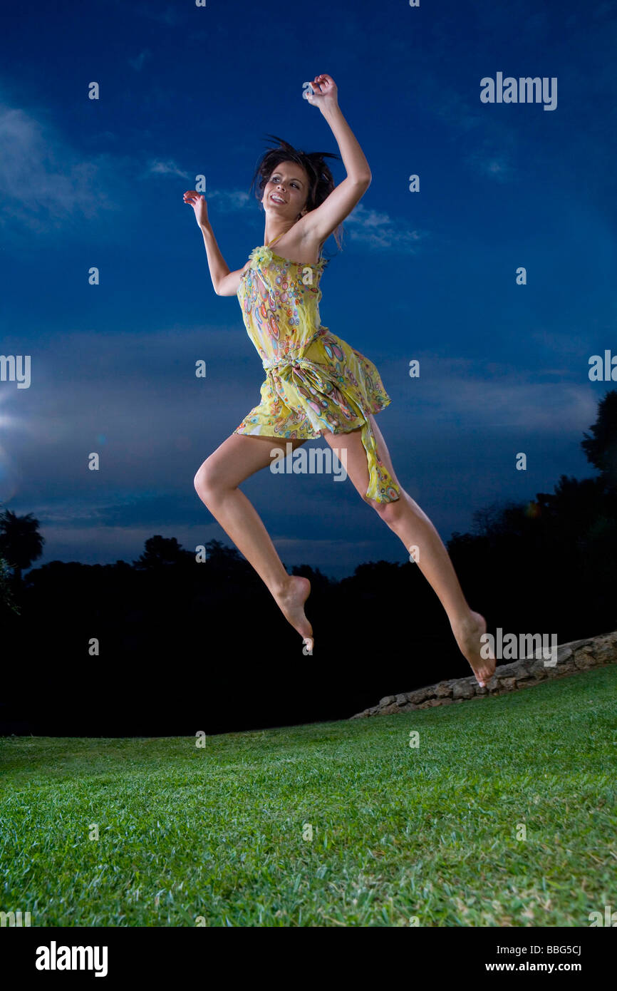 Giovane donna salta in erba Foto Stock