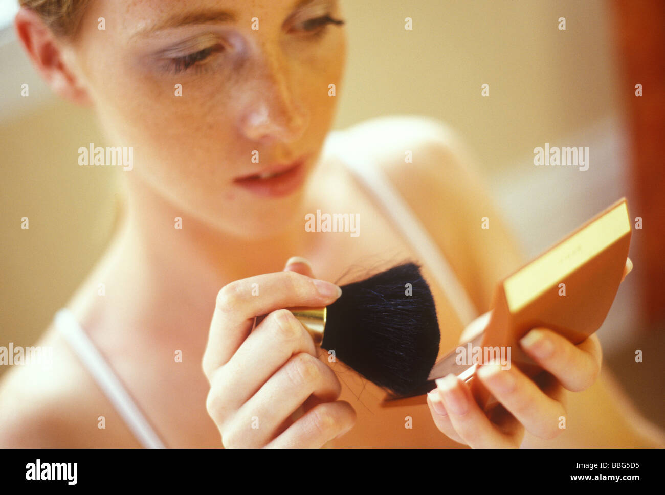 Giovane donna o ragazza adolescente applicando blusher Foto Stock