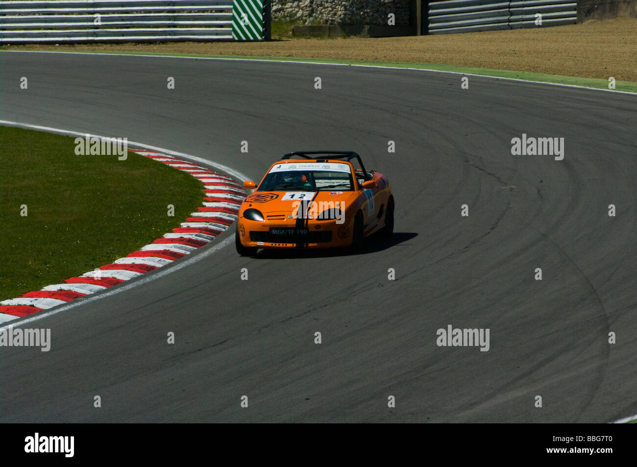 Un arancio MG TF 190 azionato da Philip Standish arrotondamento Paddock Hill Bend a Brands Hatch Kent England Foto Stock