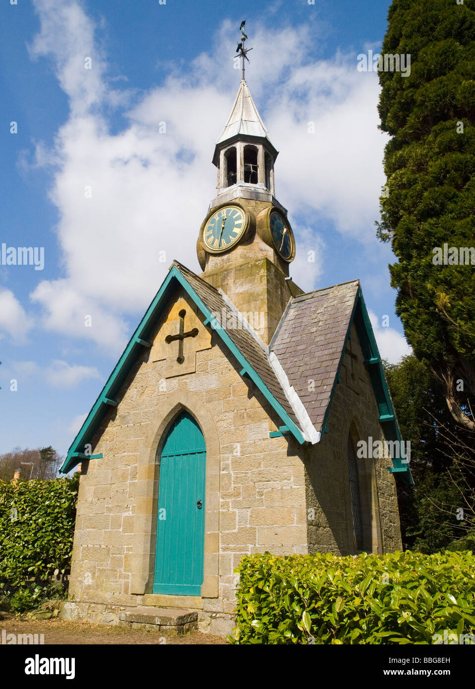 Una piccola pietra chiesa edificio con un clock tower e la banderuola, North East England Regno Unito Foto Stock
