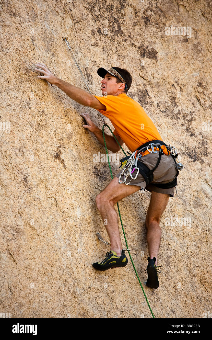 Scalatore risale una ripida roccia sbalzo. Foto Stock