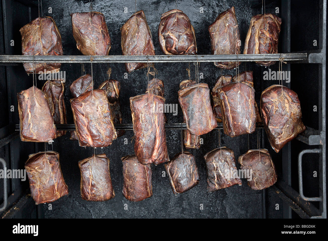 Carne di maiale affumicato giunti in un fumatore, produzione delle specialità bavaresi Schwarzgeraeuchertes, prosciutto affumicato in una macelleria in Hengersb Foto Stock
