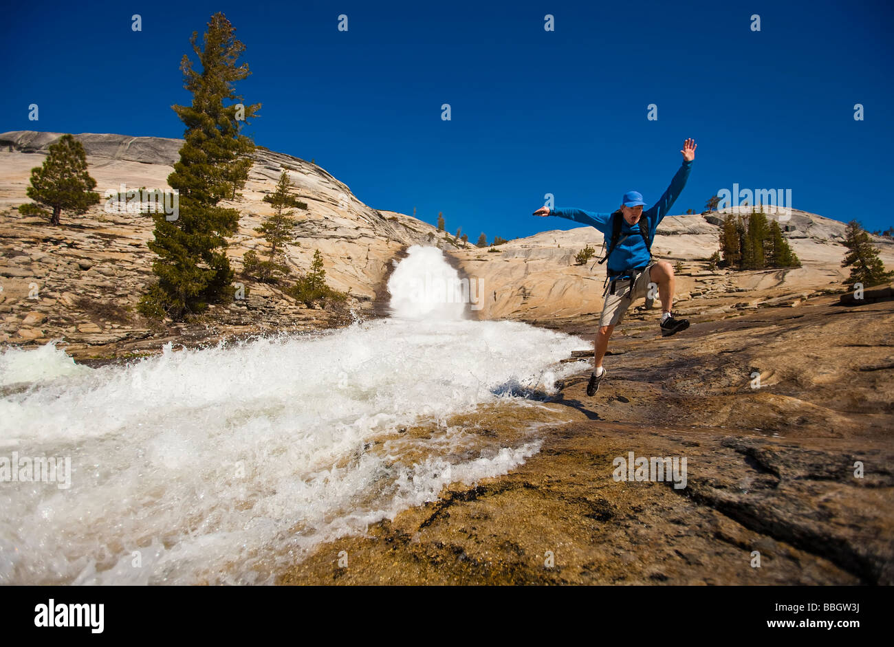 Escursionista segue un percorso lungo una cascata. Foto Stock