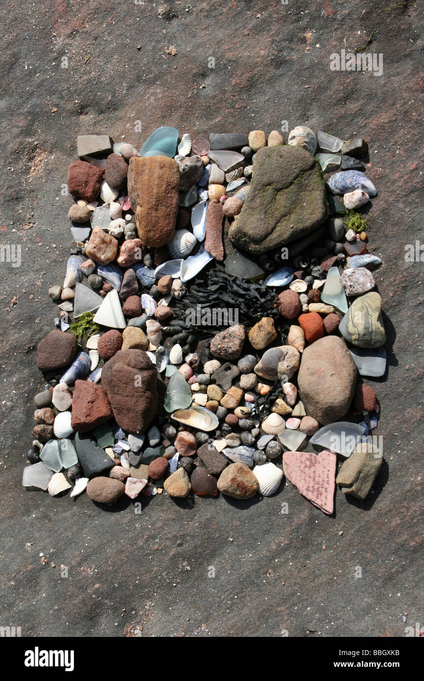 Spiaggia arte utilizzando materiali naturali di conchiglie, pietre e alghe prese a Hilbre Island, il Wirral, Merseyside, Regno Unito Foto Stock