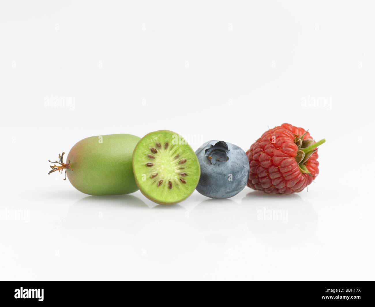 Hardy kiwi frutta mirtillo e lampone su sfondo bianco Foto Stock