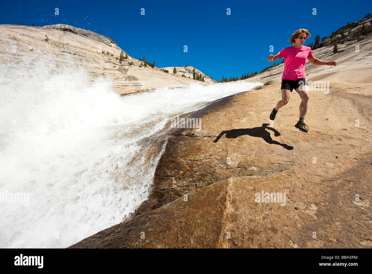 Escursionista in esecuzione un sentiero lungo il lato a cascata nel Parco Nazionale di Yosemite Foto Stock