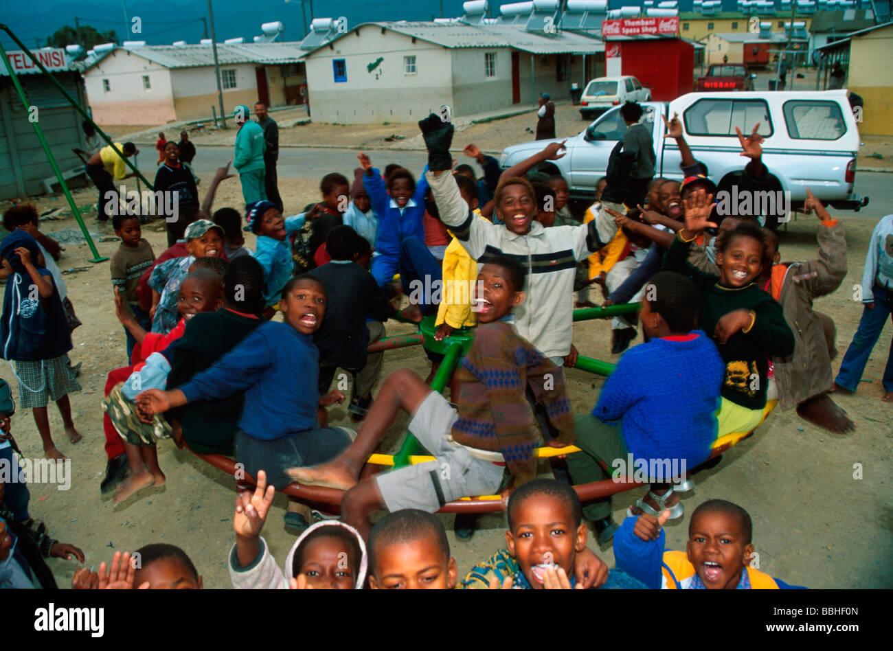 Bambini affollano su un round a bout fuori il Lwandle manodopera migrante museo su un pomeriggio nei giorni feriali Foto Stock