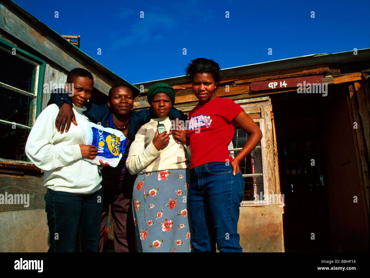 I residenti di Silahliwe pongono per la fotocamera al di fuori di uno dei loro baracche Ukuthasa ha lavorato sodo per ottenere questa terra ad essi assegnate Foto Stock