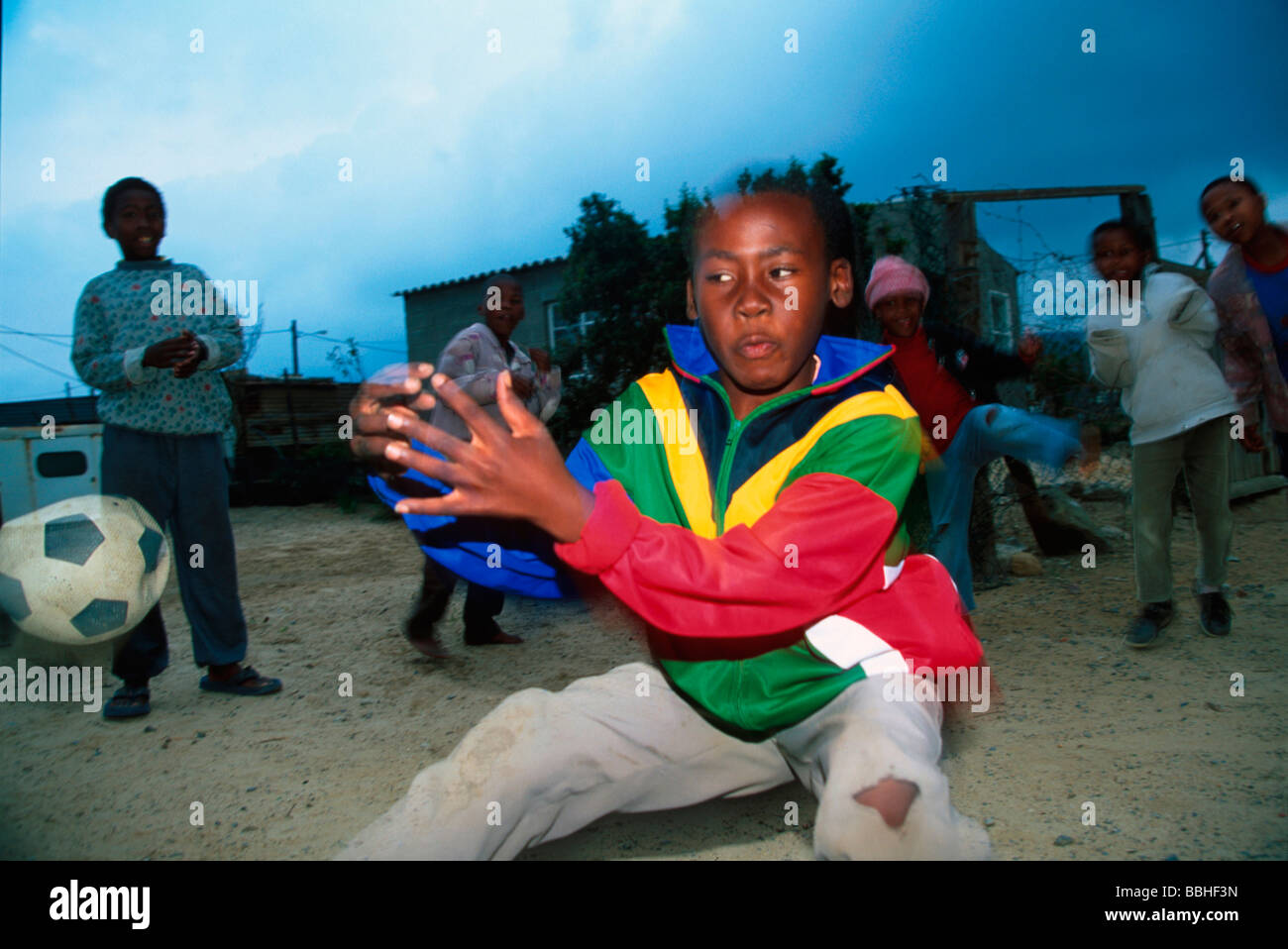 I bambini giocano a calcio la sera fuori Sindiswa BlouwÕs house Lwandle South Western Cape Sud Africa Foto Stock