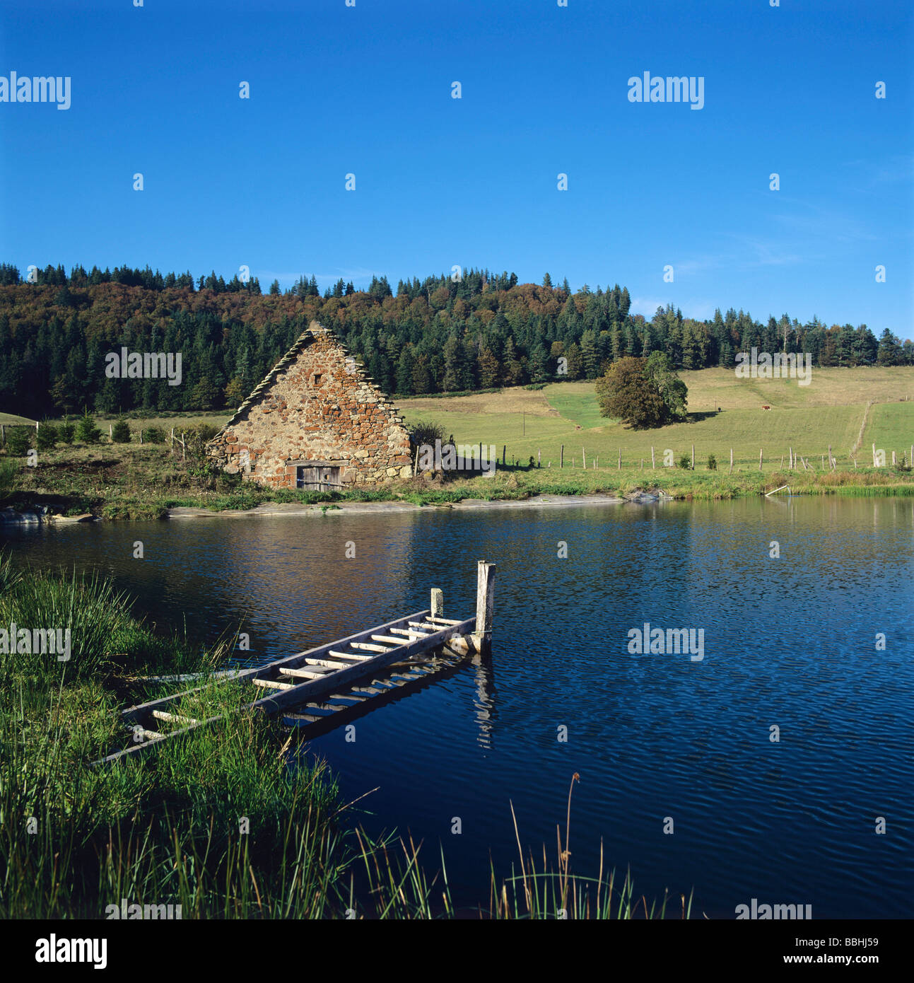 Vecchia fattoria sul bordo di un lago in Auvergne. La Francia. Foto Stock