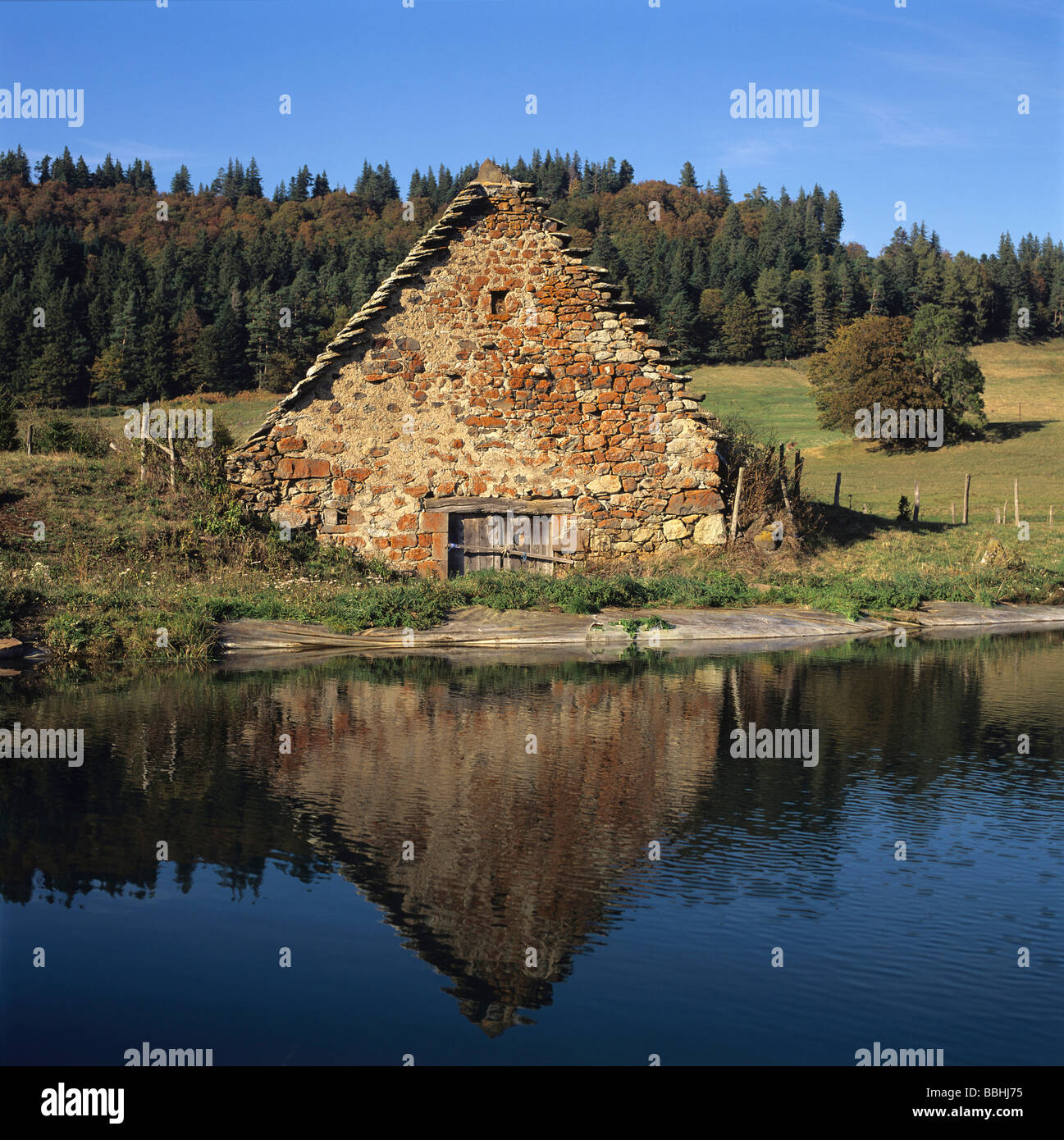 Vecchia fattoria riflessa nell'acqua. Puy de Dome. La Francia. Foto Stock