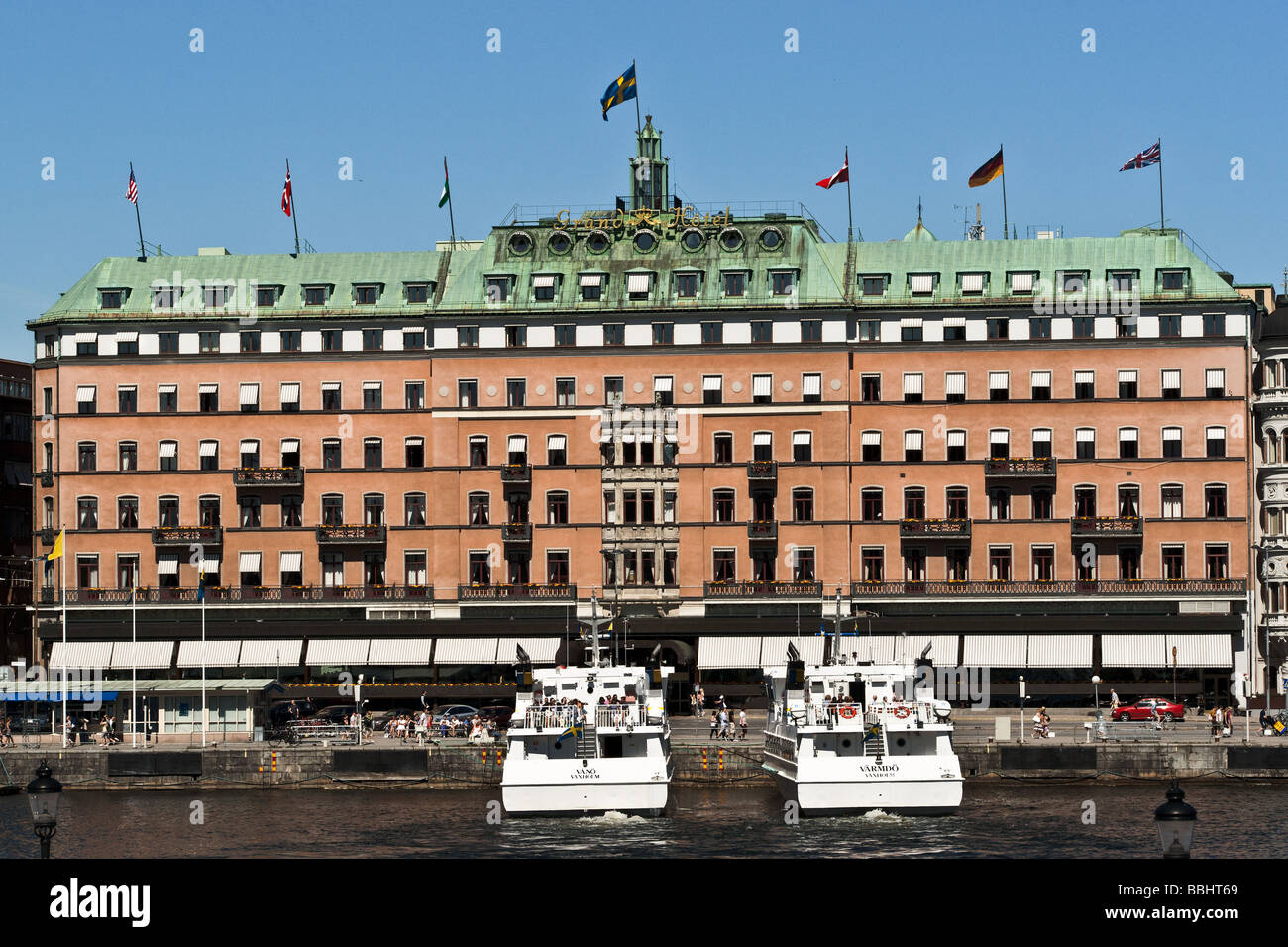 Il Grand Hotel in porto di Stoccolma, Svezia, con l'Waxholm imbarcazioni turistiche Vänö e Värmdö ancorata di fronte ad esso. Foto Stock
