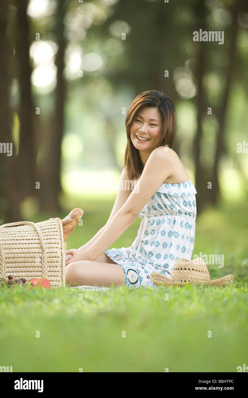 Giovane donna con picnic nel parco Foto Stock