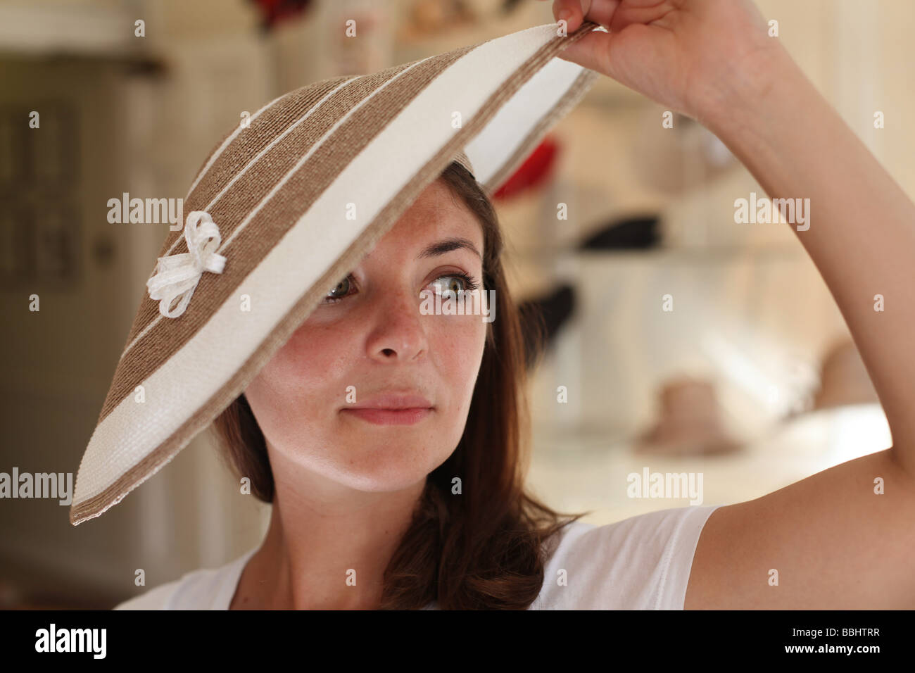 Una donna cerca su un designer hat in hat shop James Lock & Co. Numero 6 St James Street, Londra Foto Stock