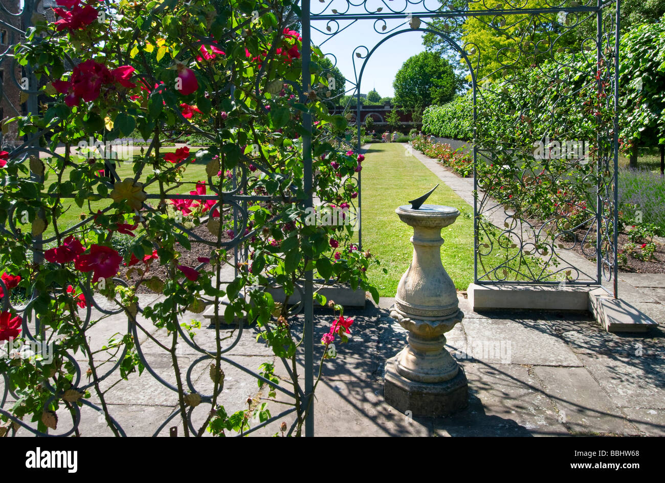 Ferro battuto trellis con rose e una meridiana in giardini privati di Lambeth Palace London REGNO UNITO Foto Stock