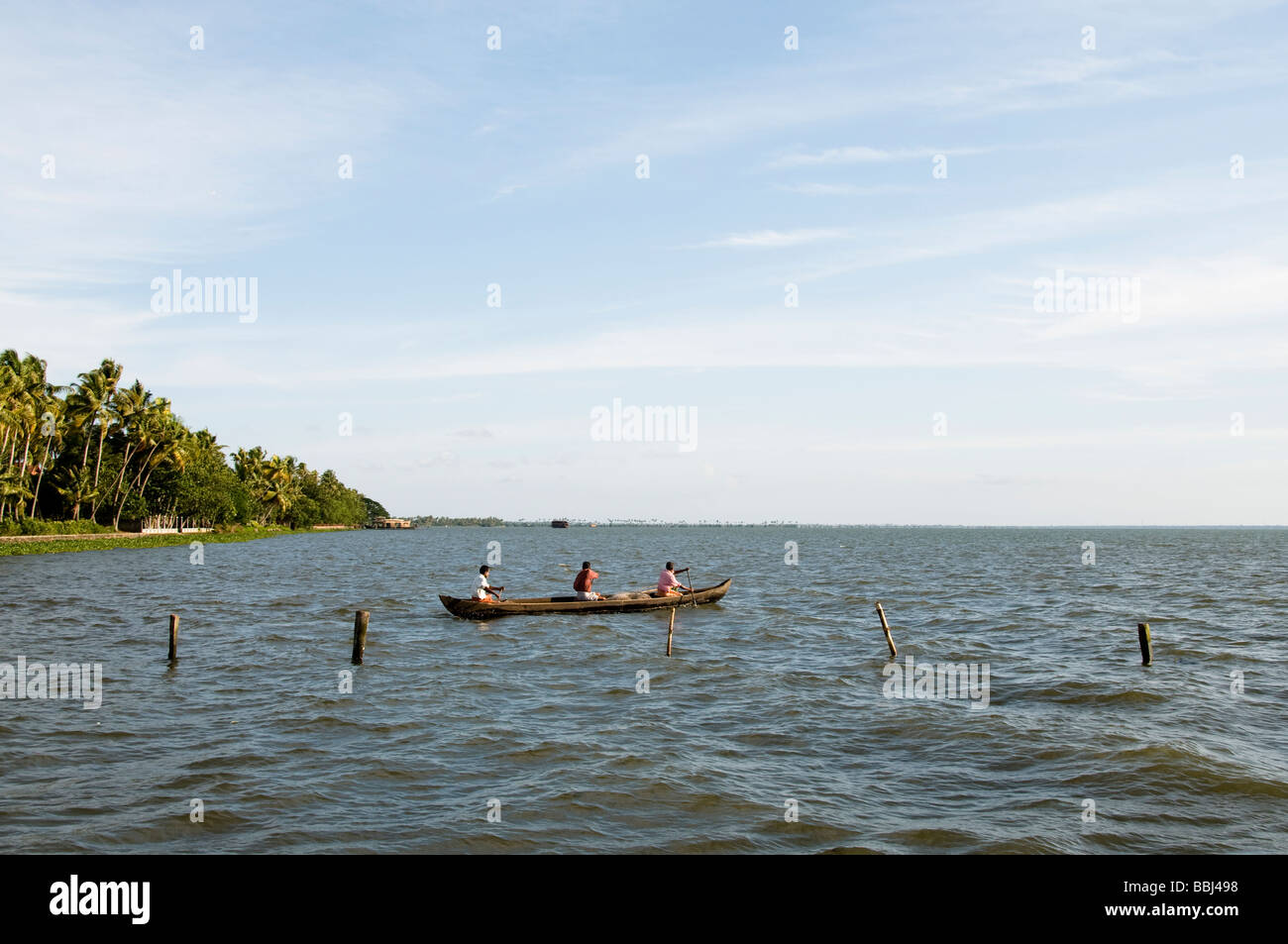 Indian pescatore in barca a remi di pesca sul lago, backwaters kerala Foto Stock