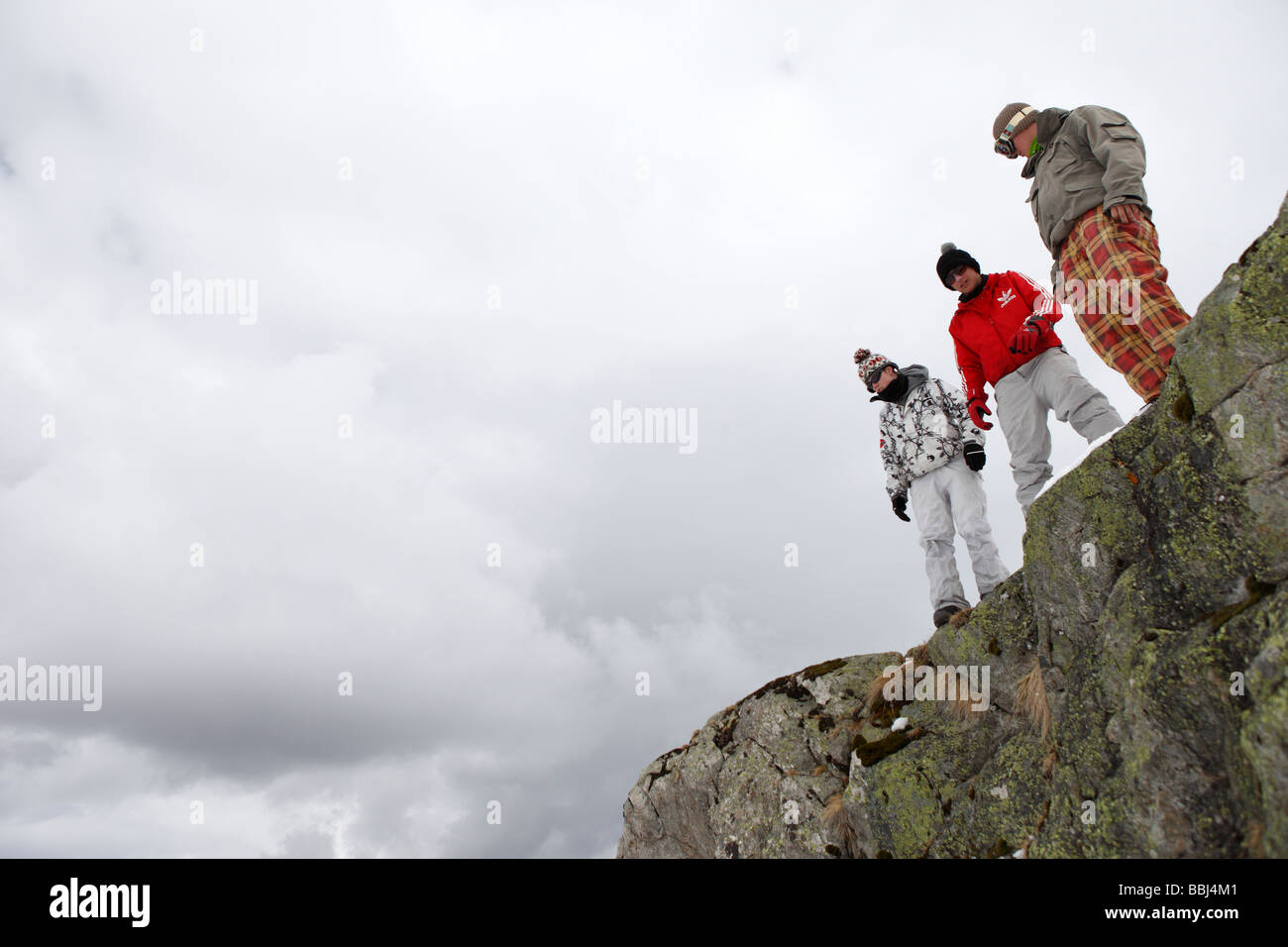 Gli sciatori prepararsi a saltare da una scogliera nella neve fresca al di sotto, per divertimento, nella località sciistica di Les Deux Alpi, alpi, Francia Foto Stock